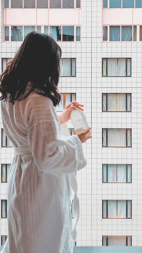 A woman standing near the window
